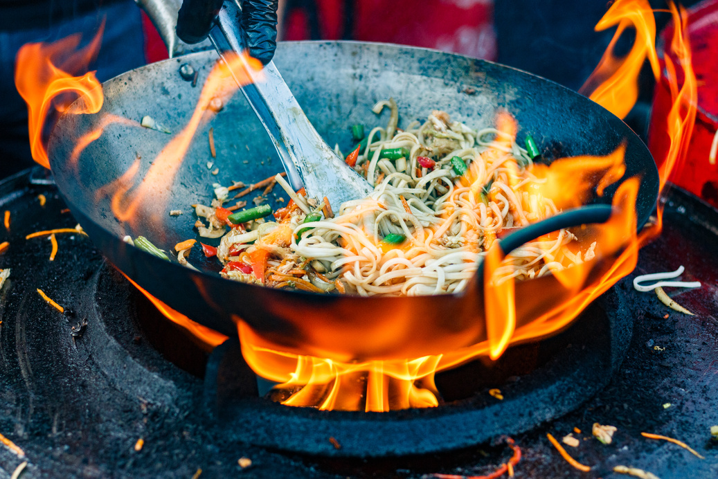 chef cooks Chinese noodle wok at street food festival